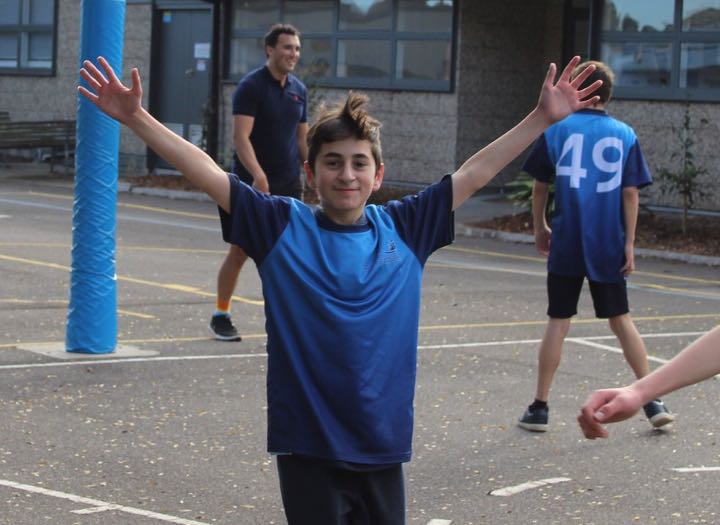 Student smiling with arms up - Hampton East School - Excellence In Inclusive Education